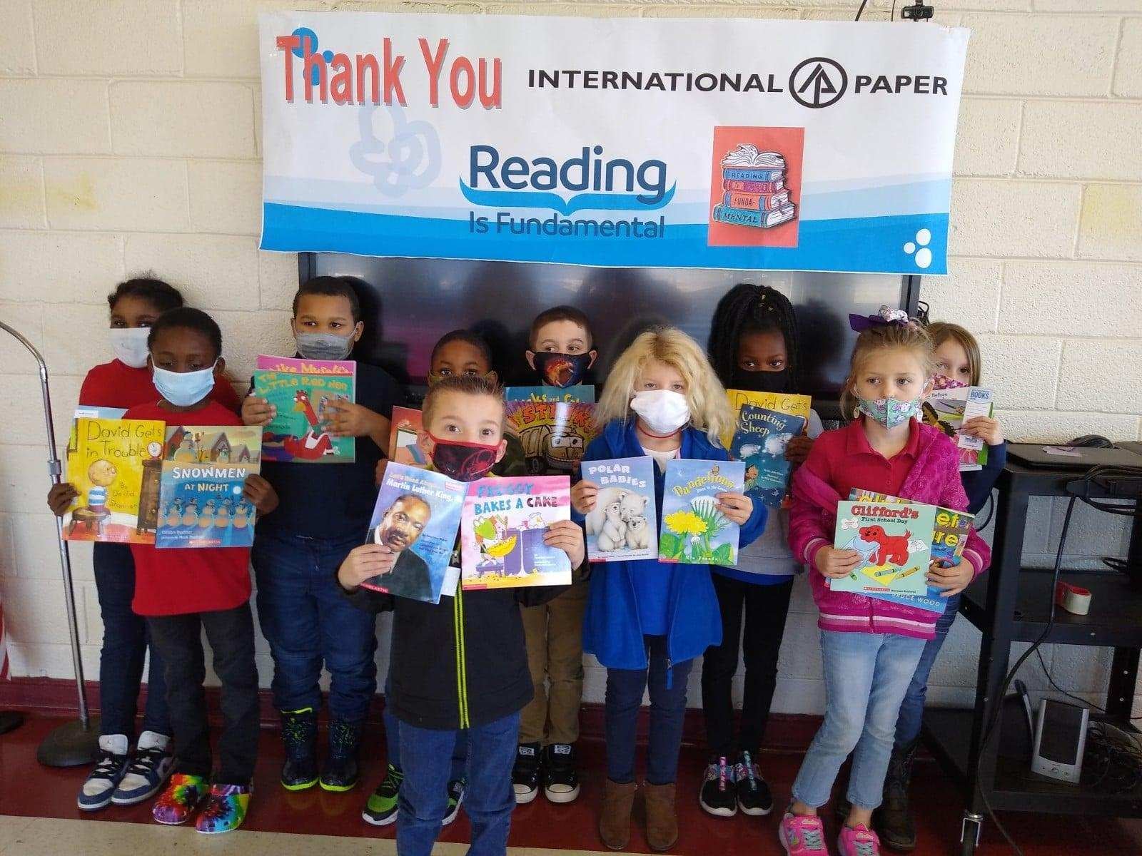 Students from Tabor City Elementary School stand in a group, each holding books and smiling. They have received these books as part of RIF's Rally to Read 100 intiative.