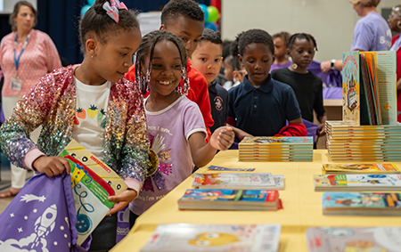 Two girls smilling at recieving books