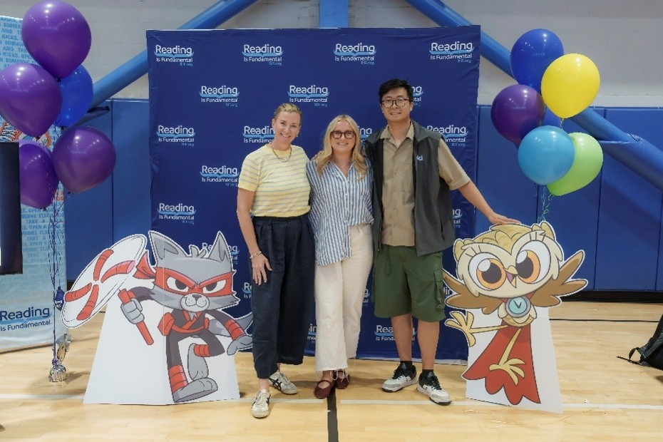 People posing for a photo with a RIF backdrop and Epic characters