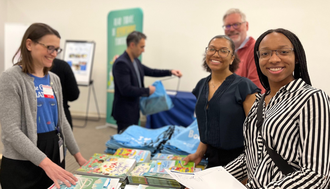 Employees smiling as they assemble literacy kits