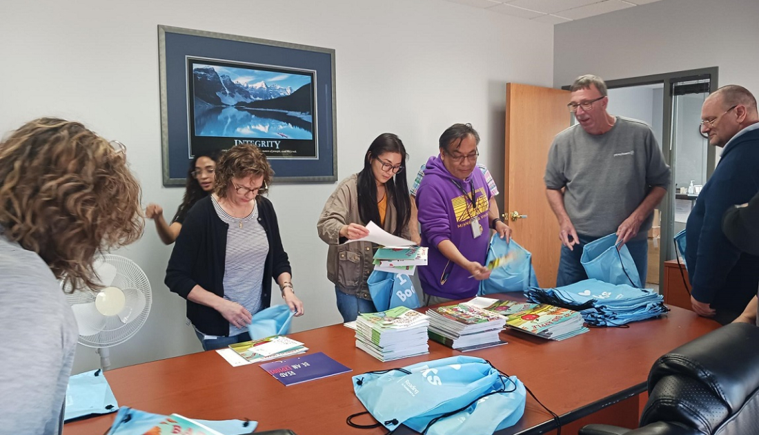 Employees putting together literacy kits