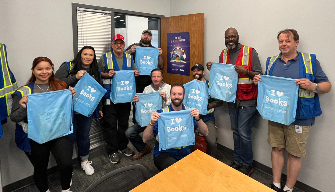 Employees posing with literacy kits