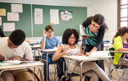 Teacher helping student in classroom
