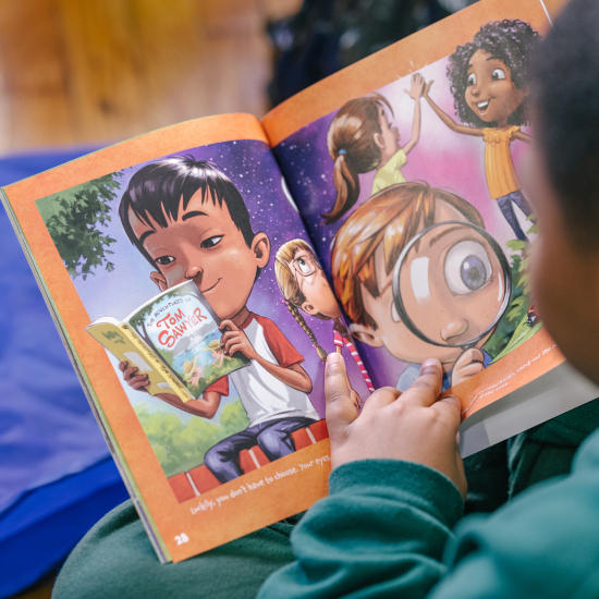 Up close view of young child reading an open book