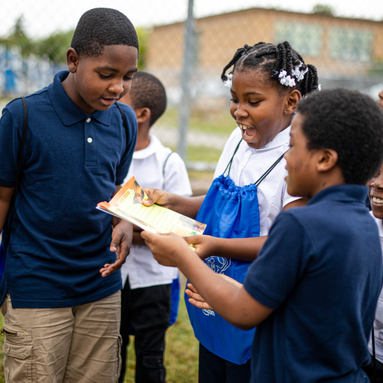 Group of children reading outside together