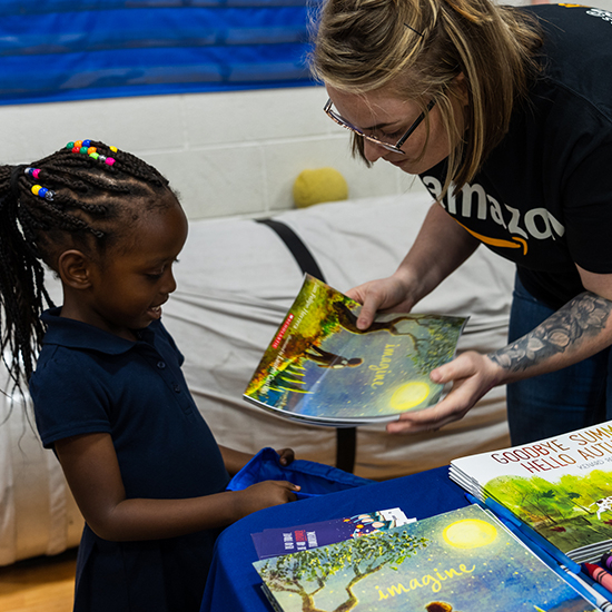 women handing a book to child