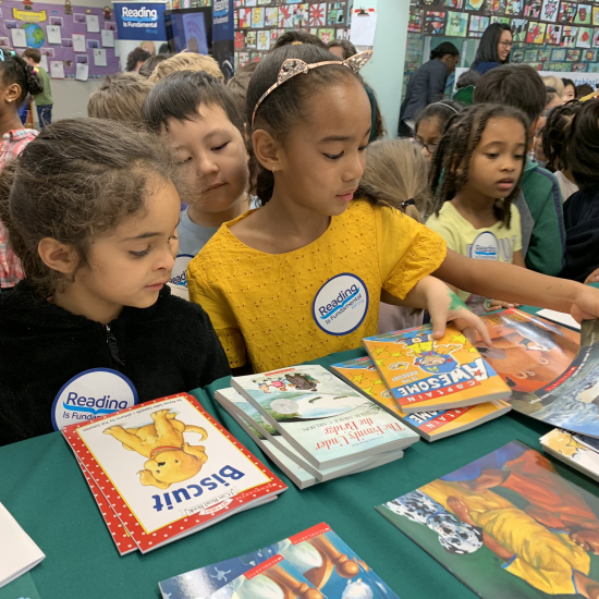 Girls looking at books on a table