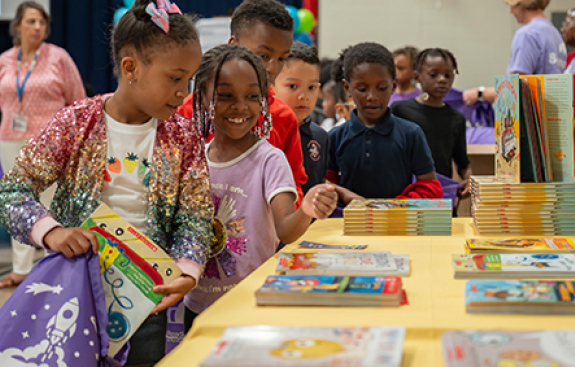 Two girls smilling at recieving books