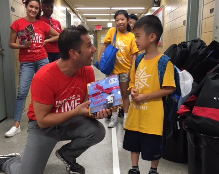 Macy's employee giving book to child - Partner with RIF