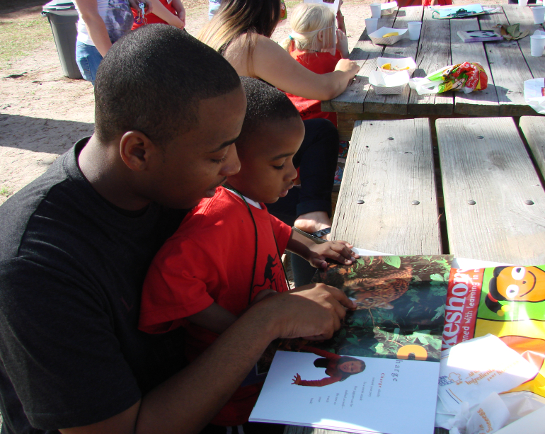 Reading together outside father and son