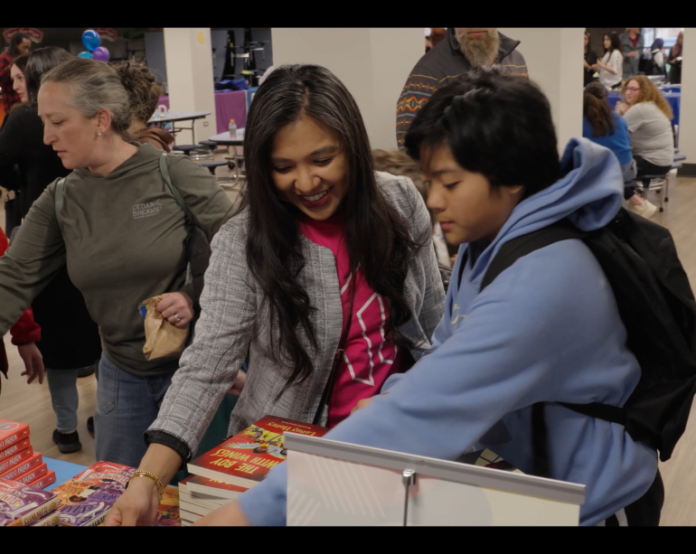 Students picking out books for event