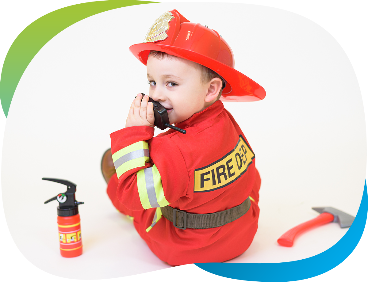 Toddler in firefighter speaking into radio