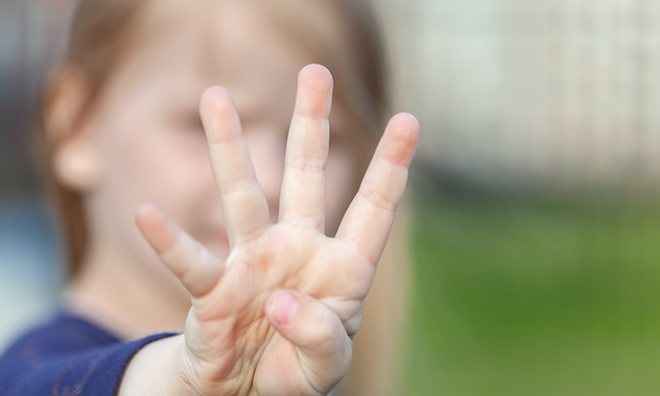 A child holds up four fingers