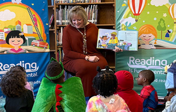 CEO Alicia Levi reading to a group of children