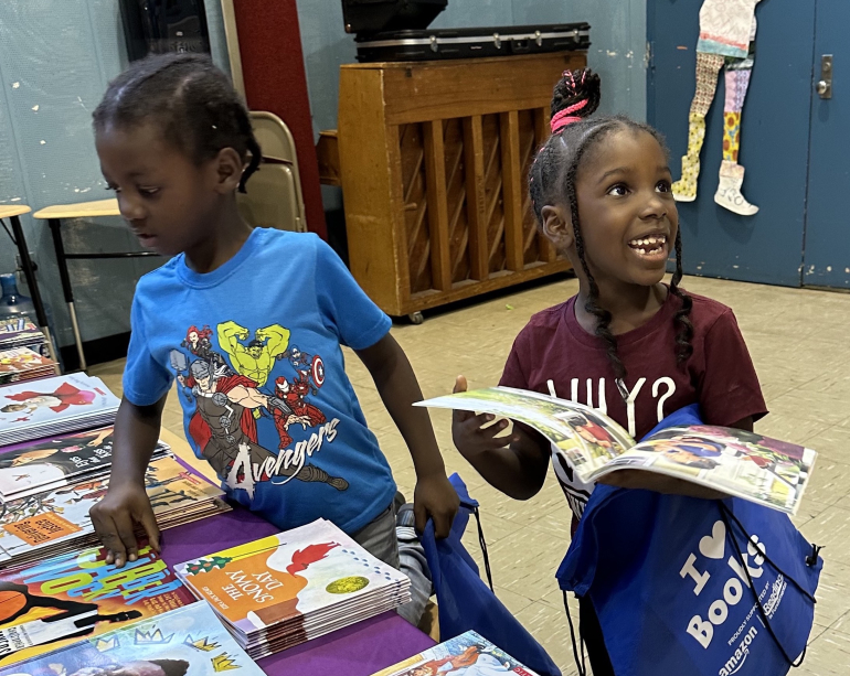 Amazon girl smiling at book selection table with RIF