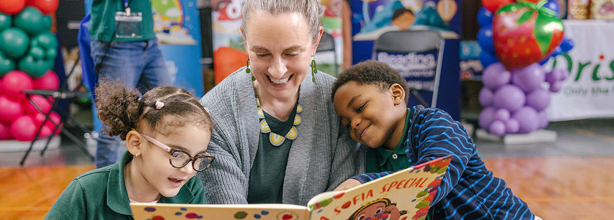 Teacher reading a book to kids